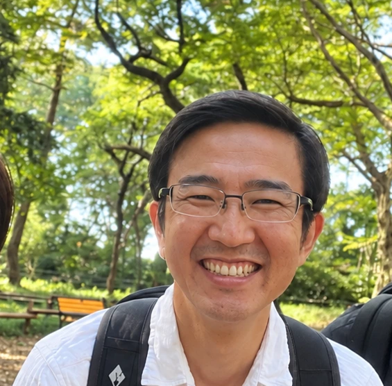 緑の公園で自然な笑顔を見せる沼尻晃一